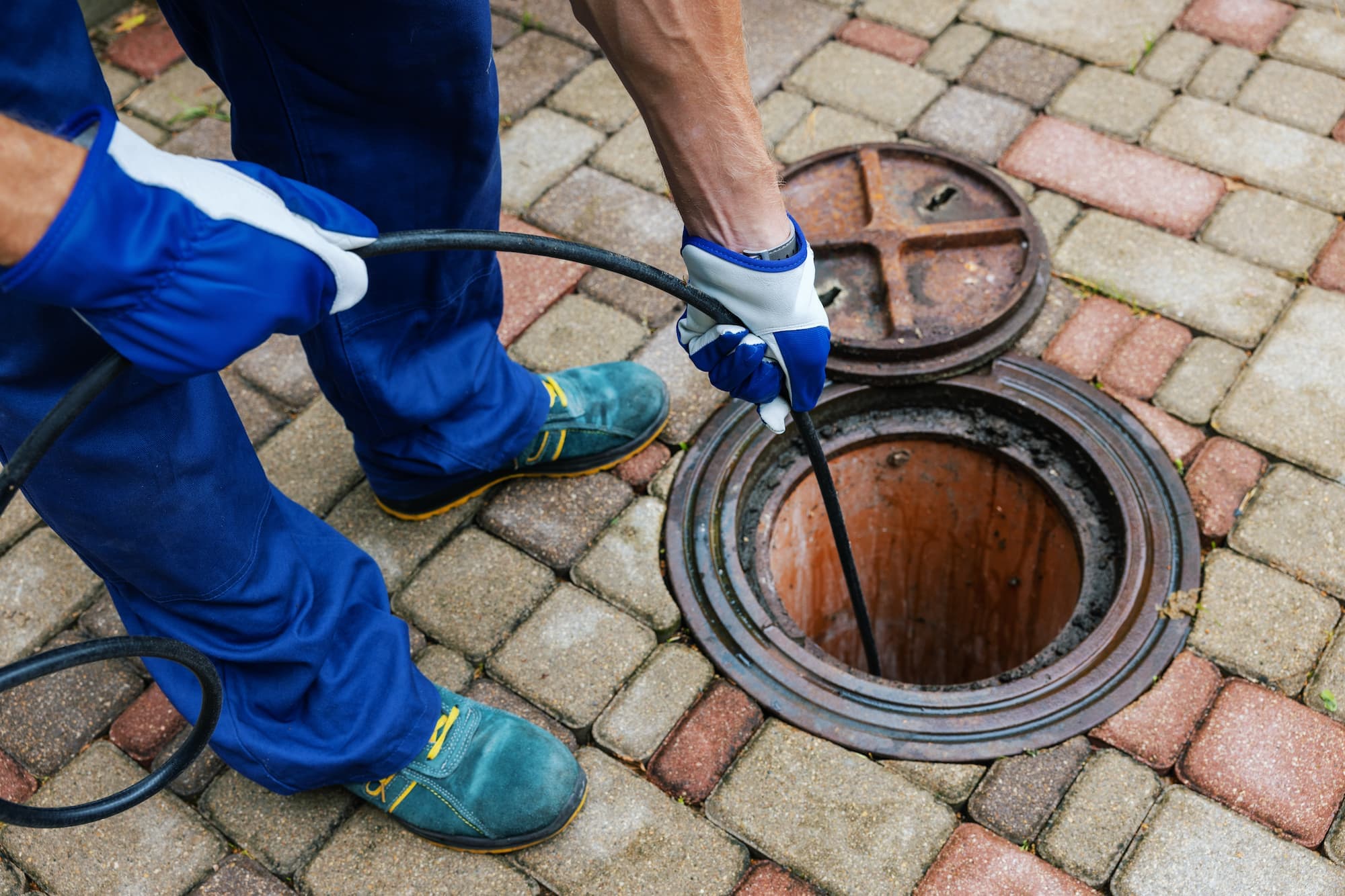 Technicien assainissement effectuant un curage haute pression de canalisation