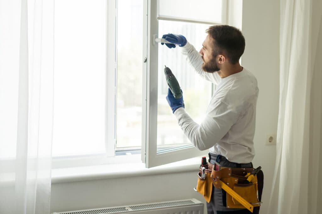 Menuisier posant une fenêtre PVC à domicile