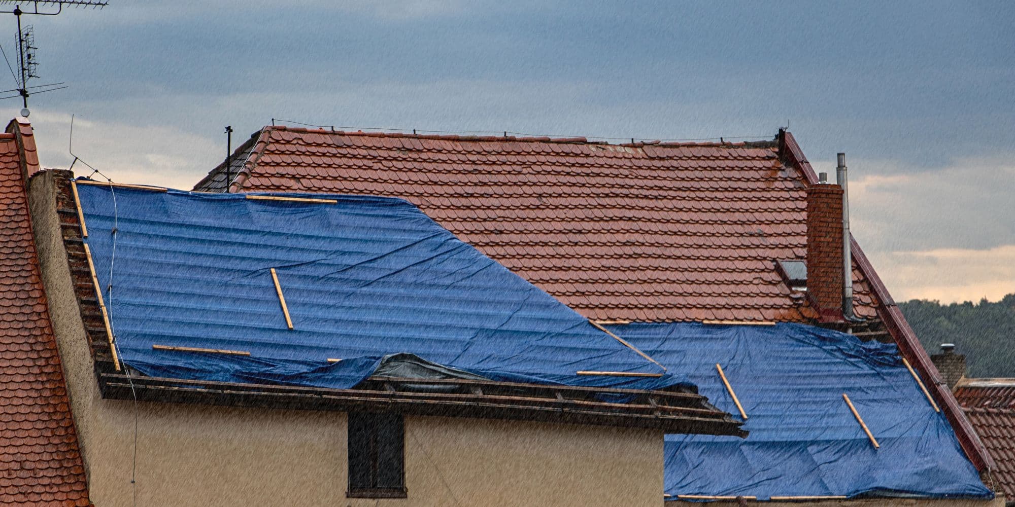 Couvreur réalisant un bâchage d'urgence après tempête à Limay