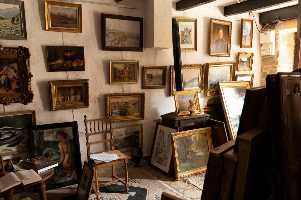 Expert examinant un tableau lors d'une estimation à Aurillac