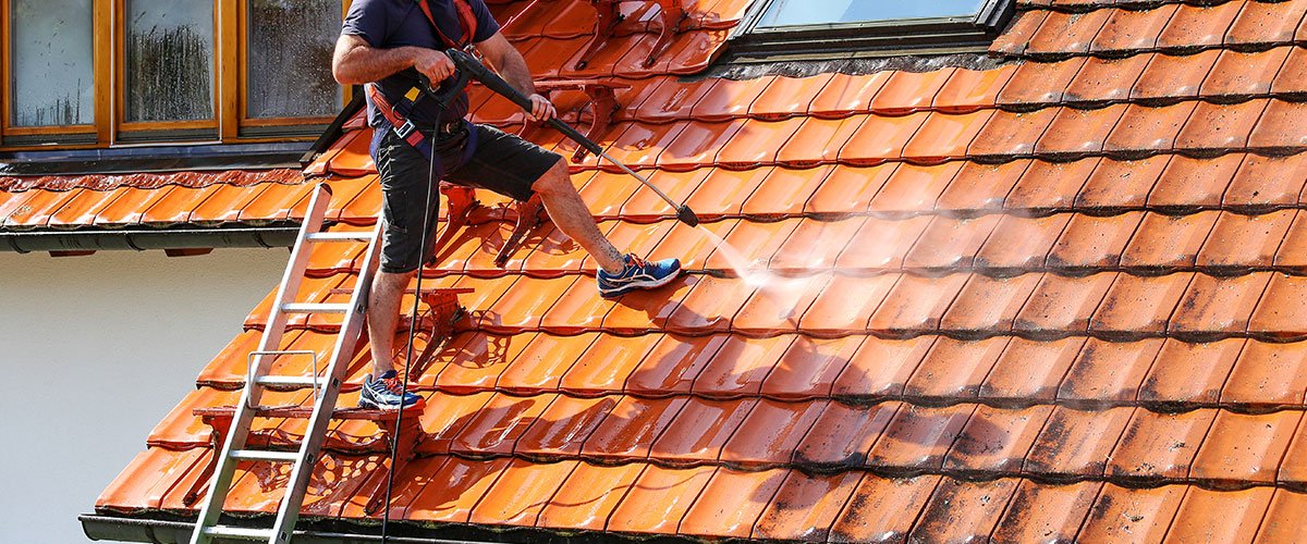 Couvreur réalisant un nettoyage et démoussage de toiture à Sainte-Soulle